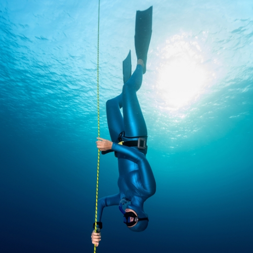 Freediver descending down a line into the water