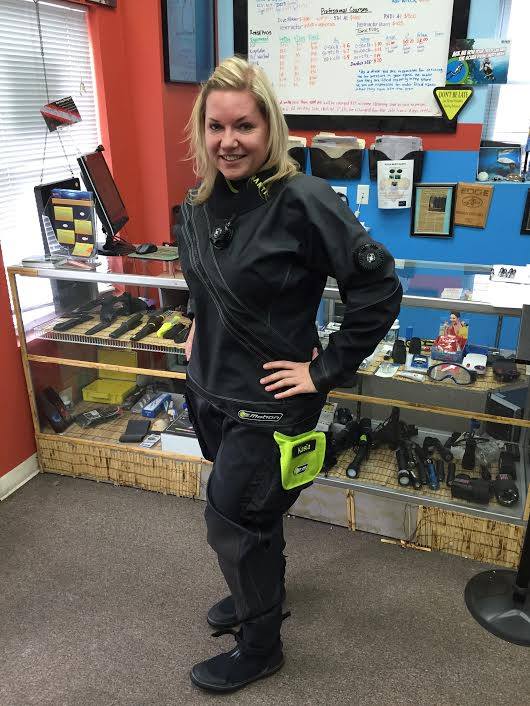 Diver in a dive shop wearing a drysuit