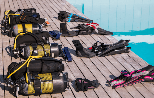 Sets of scuba gear lined up near water