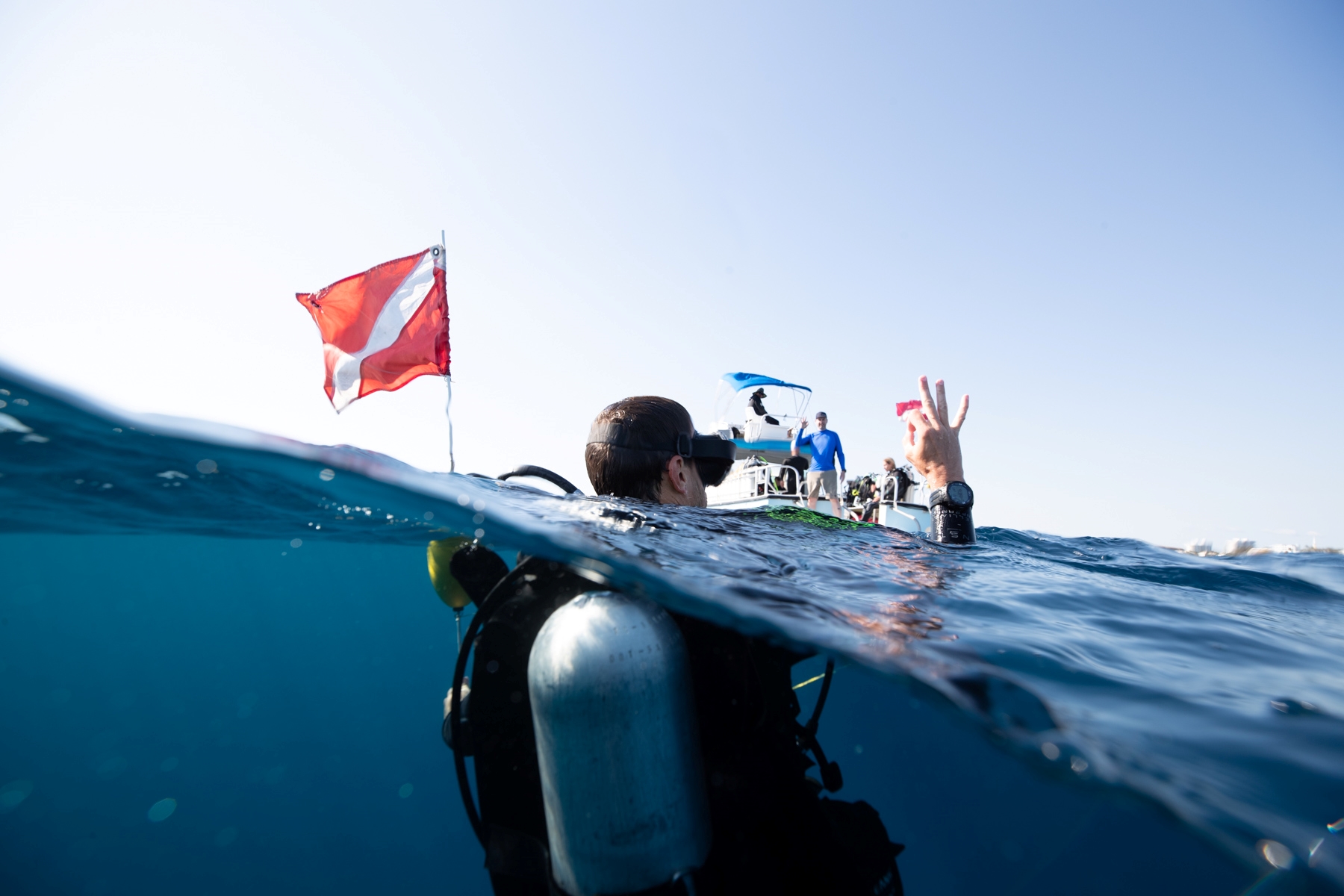 A diver above water signalling to the boat that he's ok