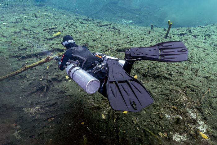 Diver swimming underwater with prominent diving fins