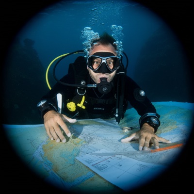 A diver underwater looking at charts and maps