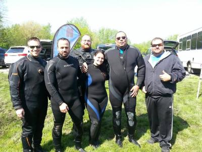 Six divers posing outdoors in their wetsuits