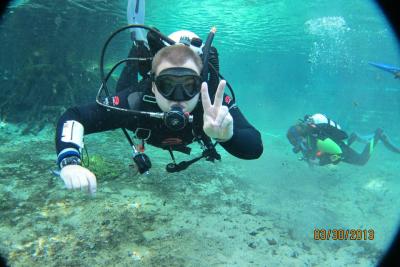 Diver underwater making a peace sign to the camera