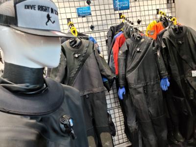 Drysuits hanging up on the wall at Dive Right In Scuba