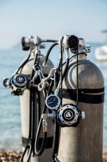 Two aluminum scuba tanks on a beach