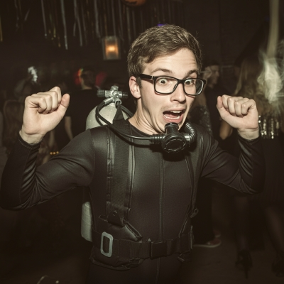 A man dressed in a scuba diver costume at a halloween party