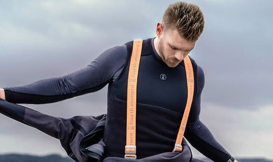 A male diver removing his drysuit. He's wearing black drysuit undergarments underneath.