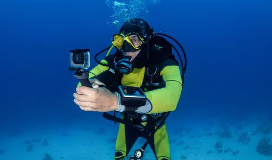 Diver underwater holding a camera using a grip mount